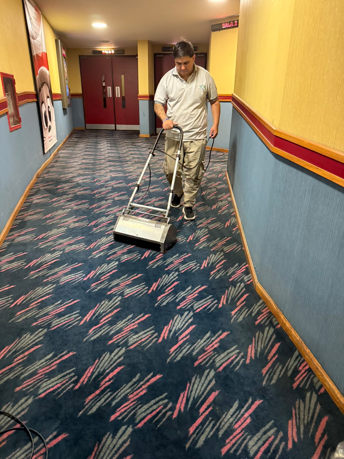 Operario Tecnoclean tratando una alfombra en un pasillo de cine